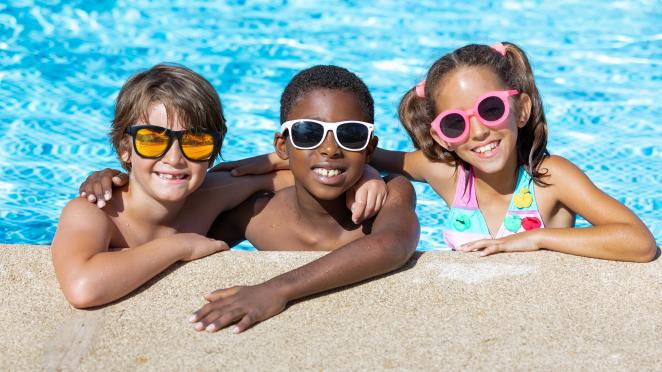 3 kids wearing sunglasses while swimming